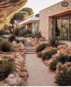 a stone house surrounded by trees and rocks with stairs leading up to the front door