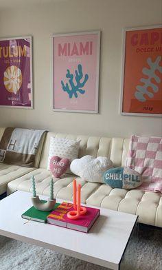 a living room filled with furniture and pictures on the wall above it's coffee table