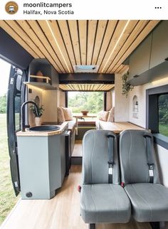 an interior view of a camper with two seats and a kitchen in the back