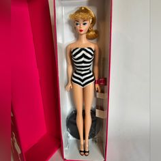 a barbie doll in a pink box with black and white stripes on it's body