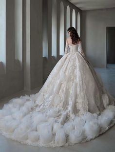 a woman in a white wedding dress is standing on the floor with her back to the camera