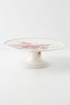 a white cake plate with flowers on it