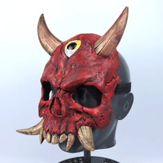 a red mask with horns on top of a head