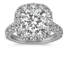 a cushion cut diamond surrounded by halos and pave set diamonds in 18k white gold