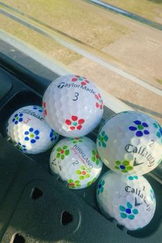 four golf balls with the name taylormade and three callaways on them in a car