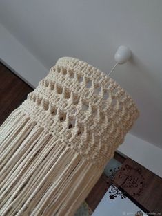 a crocheted macrame hanging from the ceiling with a white light on it