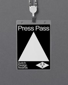 a badge hanging from the side of a gray wall that says press pass dutch design awards