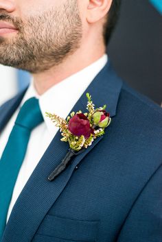 a man in a suit and tie with a boutonniere on his lapel