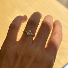 a person's hand with a diamond ring on it