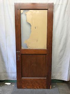 an old wooden door with glass on the bottom and side paneling, in front of a