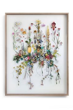 an art work with various flowers and plants on white paper, framed in wooden frame