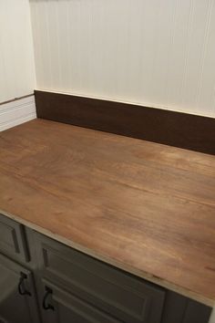 the counter top is made from wood and has two drawers on each side, with one drawer closed