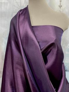 a mannequin wearing a purple dress on top of a table