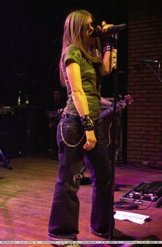 a woman standing in front of a microphone on stage