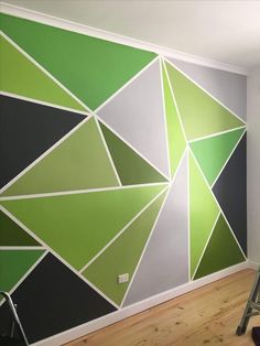 a green and white wall with some paint rollers next to it on the floor