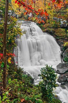 a waterfall surrounded by trees in the fall