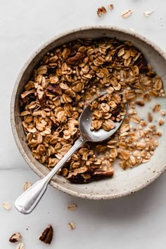 an oatmeal bowl with granola in it and a spoon next to it