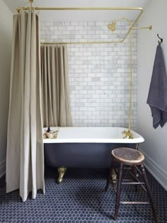 a bathroom with a bathtub, stool and shower curtain