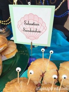 sandwiches with googly eyes are on sticks in front of a sign that says sebasian sandwitches