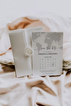 a save the date card with a ring on top of it next to a calendar