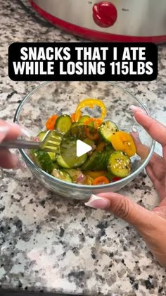 a person holding a fork in a bowl filled with vegetables