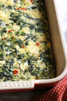 an omelet with spinach and cheese in a skillet on a table