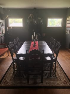 a dining room table with chairs and a rug on the floor in front of it