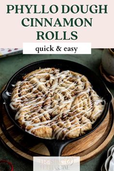 a skillet filled with cinnamon rolls on top of a wooden cutting board