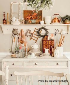 a white dresser topped with lots of clutter and decor on it's side