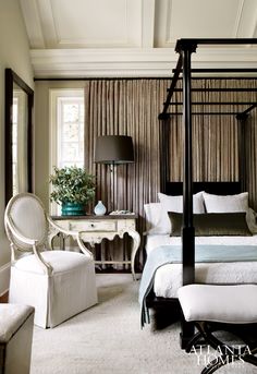 a bedroom with a four poster bed and white furniture