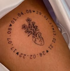 a tattoo on the back of a woman's leg with flowers and words written in cursive writing