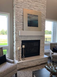 a living room filled with furniture and a fire place in front of a large window