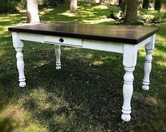 a white table with black top in the grass