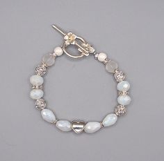 This bracelet has two types of faceted white beads with sparkly silver spacer beads and beadcaps. A silver heart and flower toggle clasp completes the bracelet. Bracelet is 7 3/4" long. Silver Accents, Toggle Clasp, White Beads, Faceted Bead, Silver Heart, Spacer Beads, Jewelry Bracelets, Beaded Bracelets, Bracelet