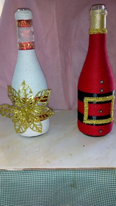 two wine bottles decorated with gold and silver glitters, one is white and the other is red