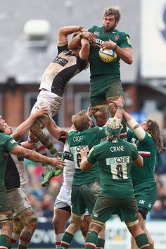 a group of men are playing rugby on the field