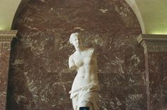 there is a statue in the middle of a room with marble walls and flooring