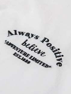 there is a white shirt with black lettering on the front and back, that says always positive