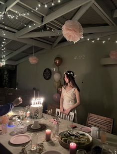 a woman standing in front of a table filled with plates and cake on top of it