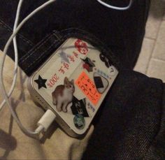 a cat is sitting on the back of someone's jeans with an ipod charger attached to it