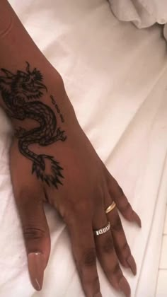 a woman's hand with a dragon tattoo on it