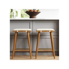 two wooden stools sitting in front of a counter top with fruit on the table