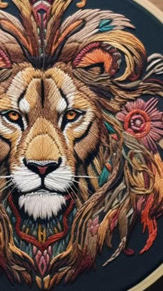 a close up of a embroidery on a piece of cloth with a lion's face