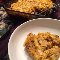 a white plate topped with macaroni and cheese next to a casserole dish