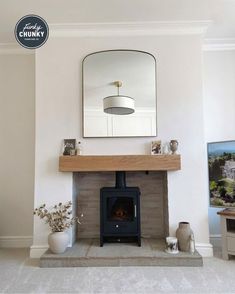 a living room with a fireplace and mirror on the wall