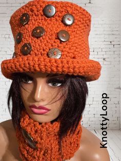 a mannequin head wearing an orange knitted hat and scarf with buttons on it