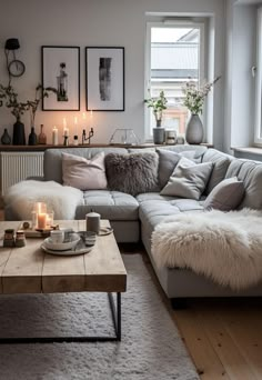 a living room filled with lots of furniture and candles on the coffee table in front of it