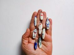 a person's hand holding several different shaped objects in their palm on a white surface