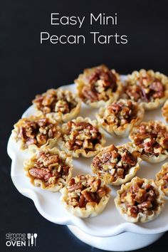 a white plate topped with mini pies covered in nuts