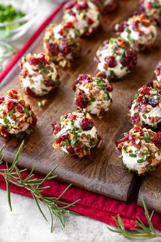 small appetizers are arranged on a cutting board with garnishes and herbs